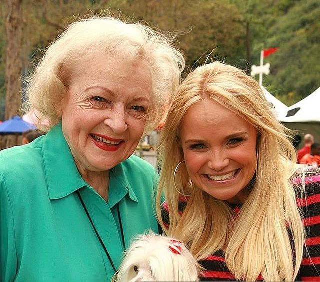 Junie Chenoweth with her pet and daughter in light green dress.
